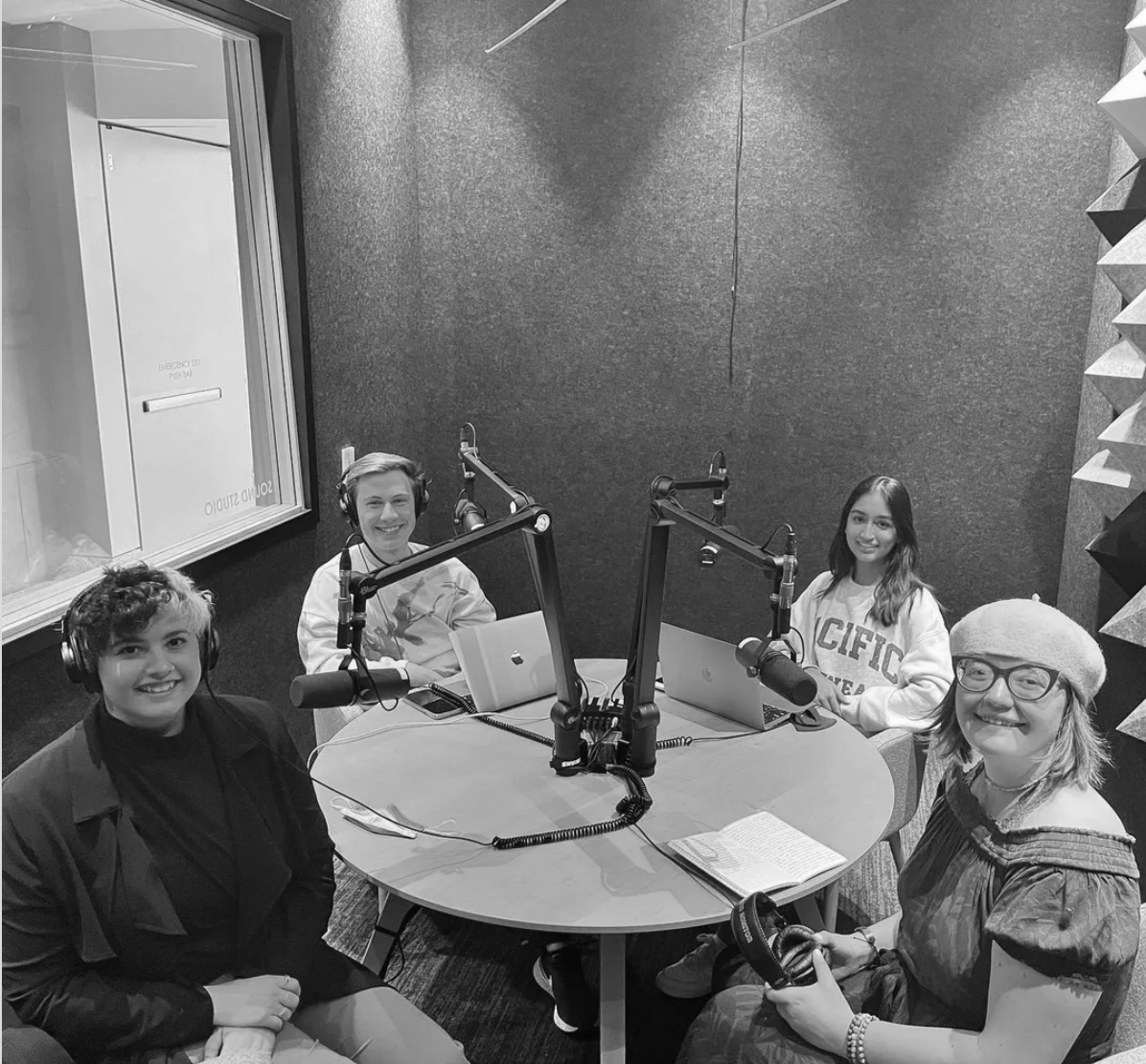Group of 4 youth sitting in a podcast studio, smiling at the camera.