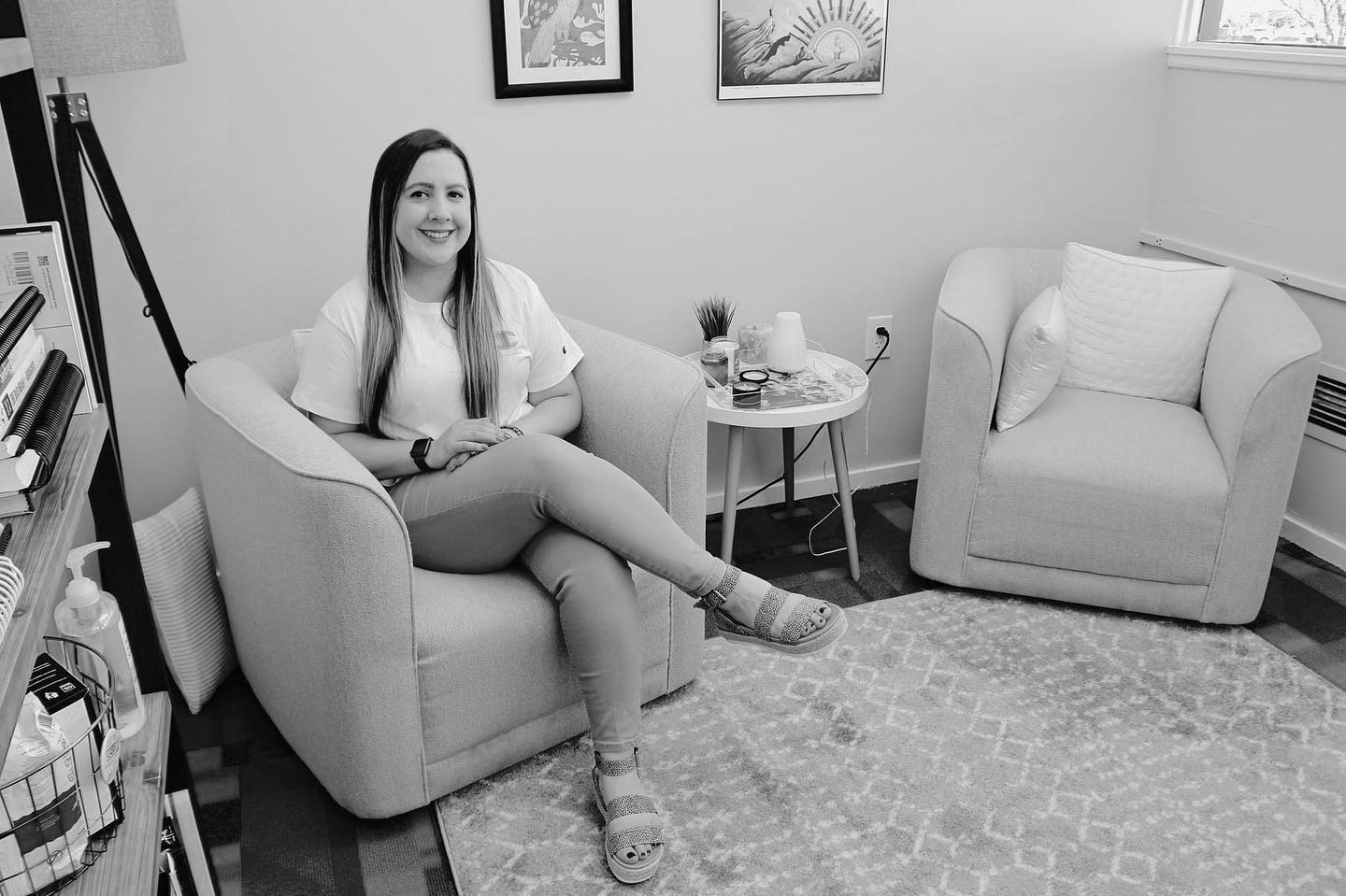 Wide shot of mental health counselor sitting in a comfy room facign the camera.